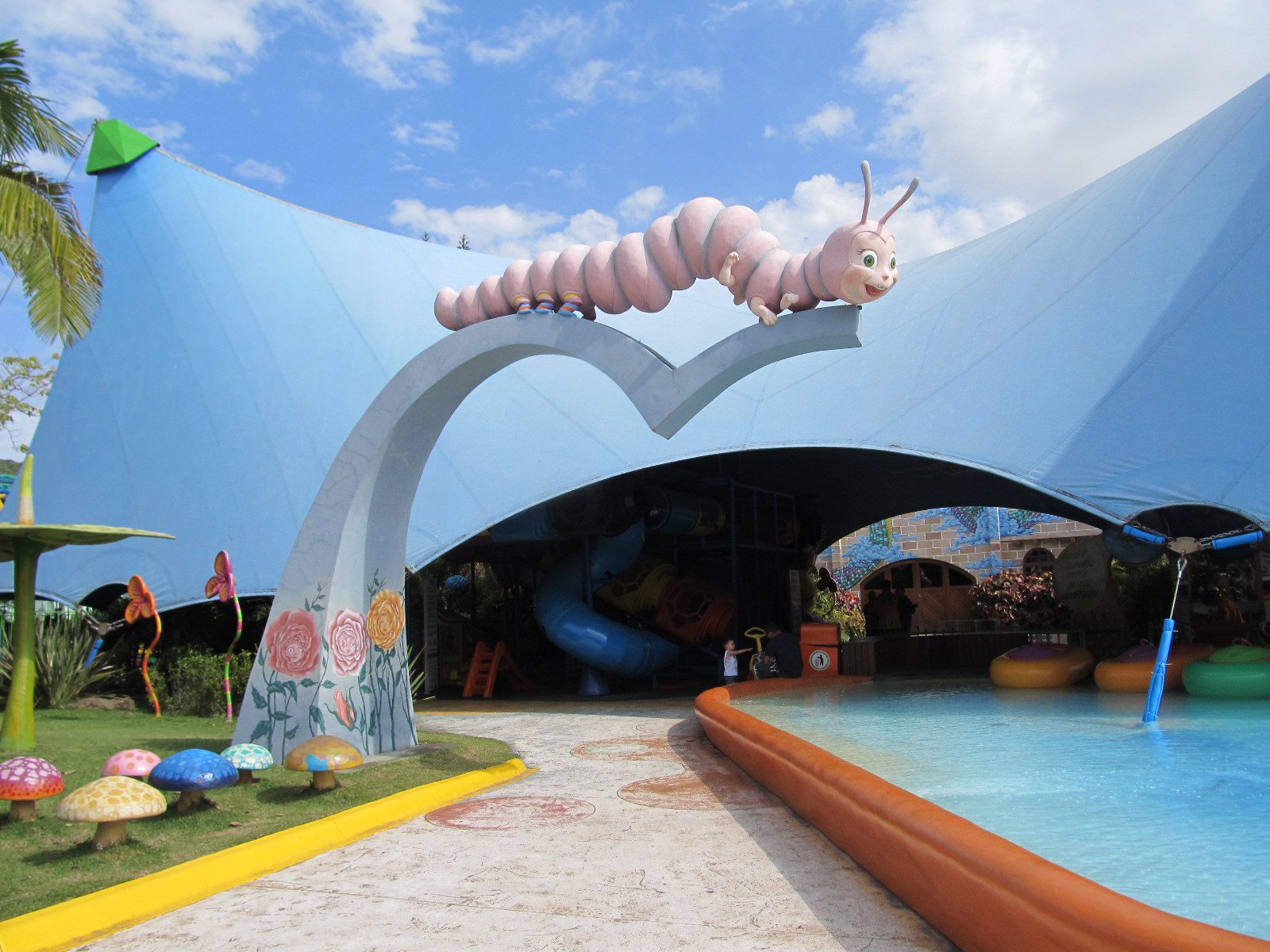 Área infantil com toboágua e escultura de lagarta