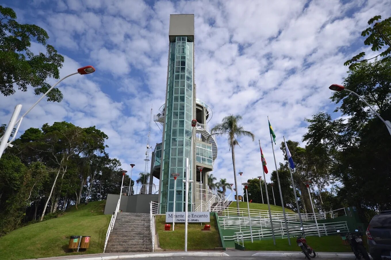 Torre do Mirante do Encanto vista de baixo, com a placa e as bandeiras na entrada