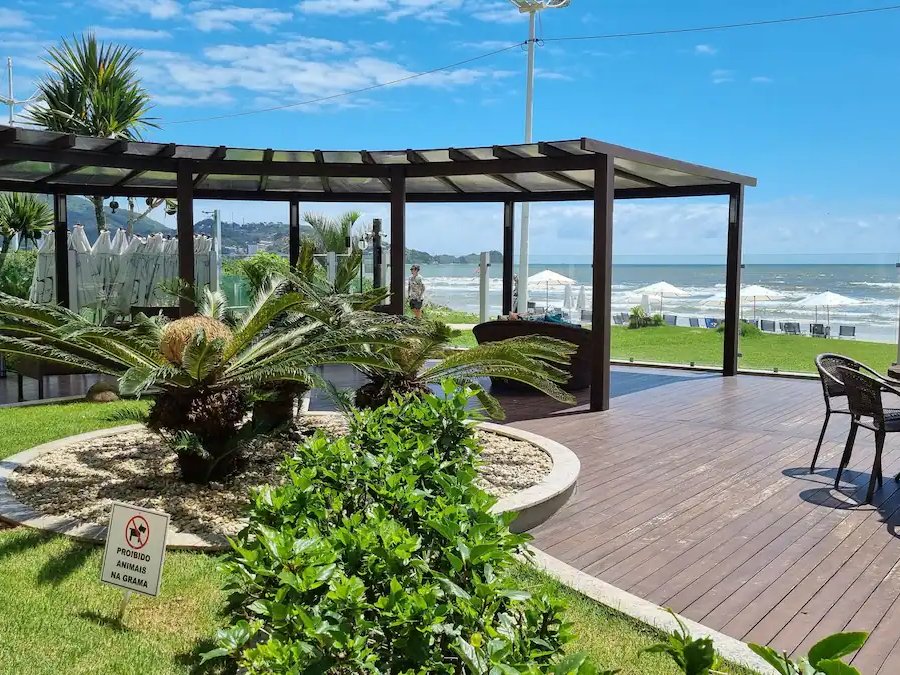 Deck de madeira e jardim do condomínio, de frente pro mar