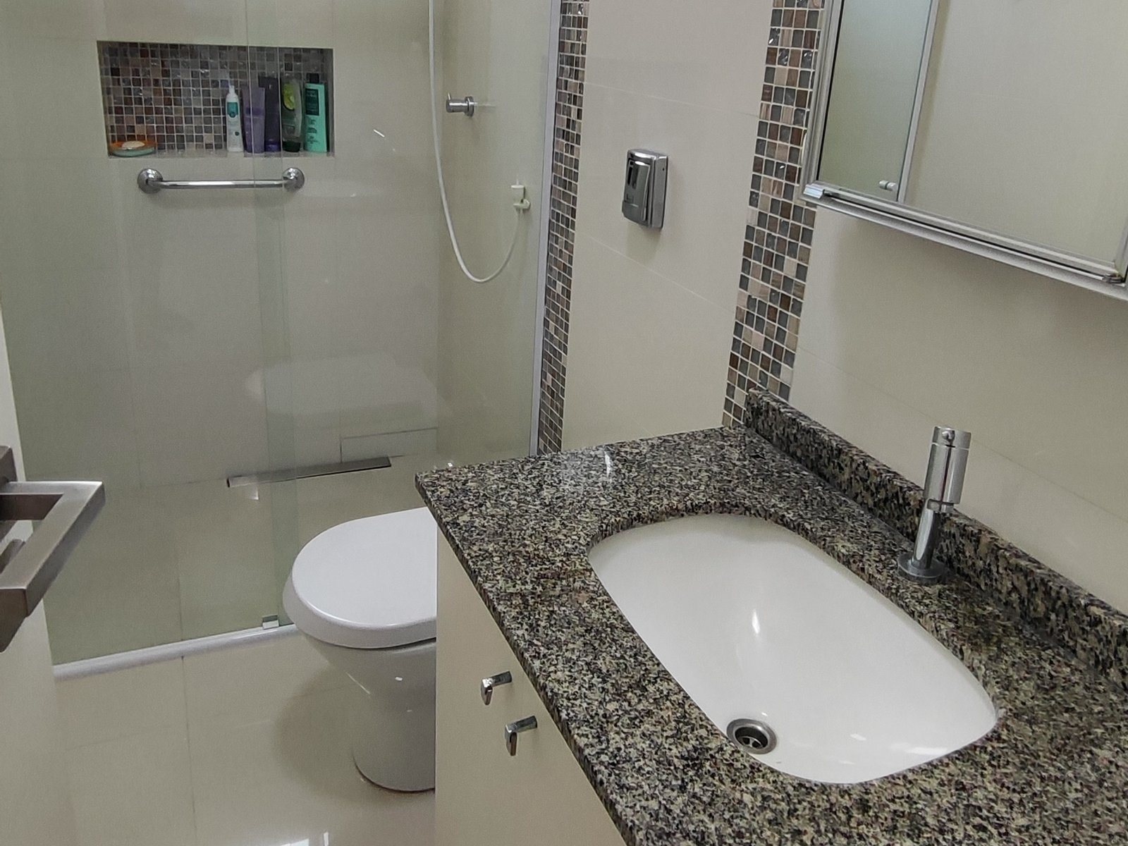 Banheiro com box de vidro e bancada de granito