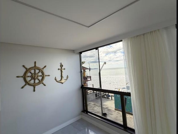 Suíte com janela de frente pro mar e decoração náutica