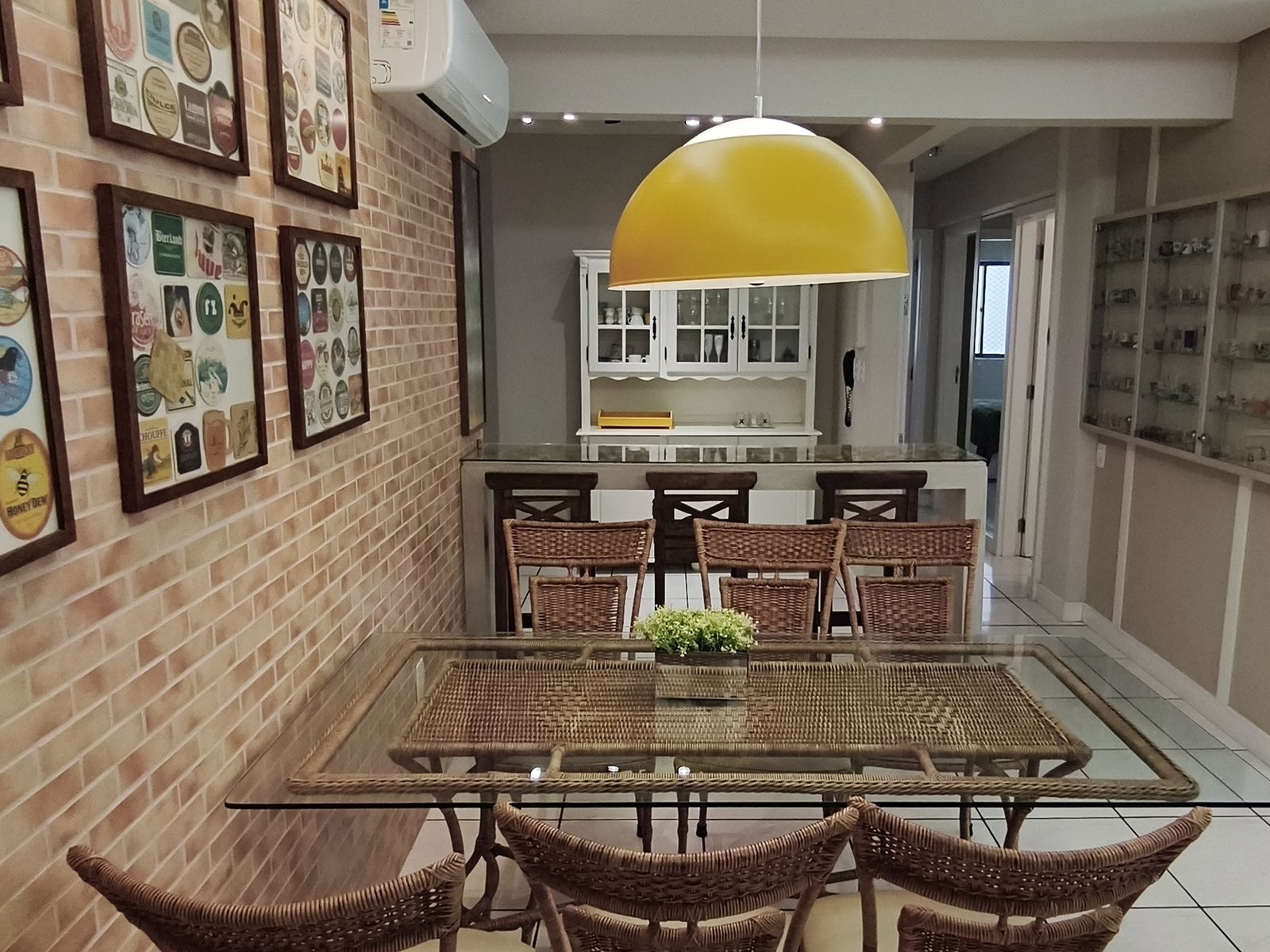 Mesa de jantar de vidro com parede de tijolo aparente