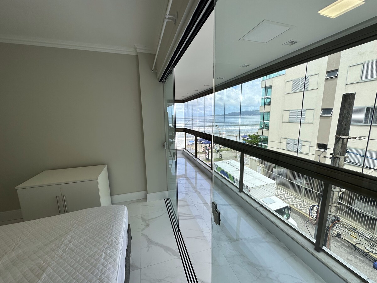 Sacada envidraçada vista do quarto, com o mar ao fundo