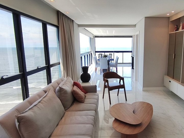 Sala de estar com sofá e vista mar