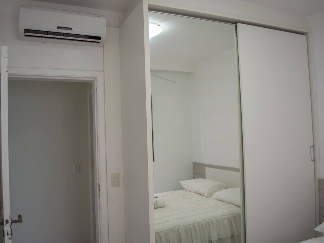 Quarto com cama de casal e guarda-roupa espelhado