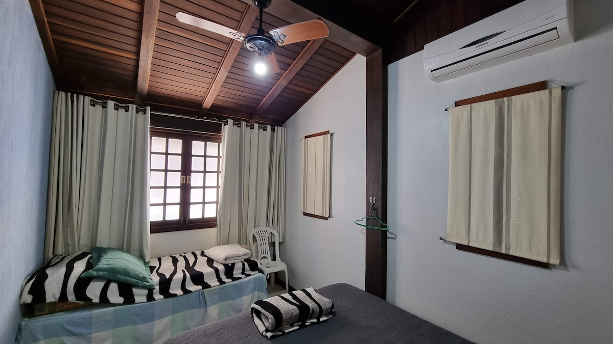 Quarto com cortinas e teto de madeira