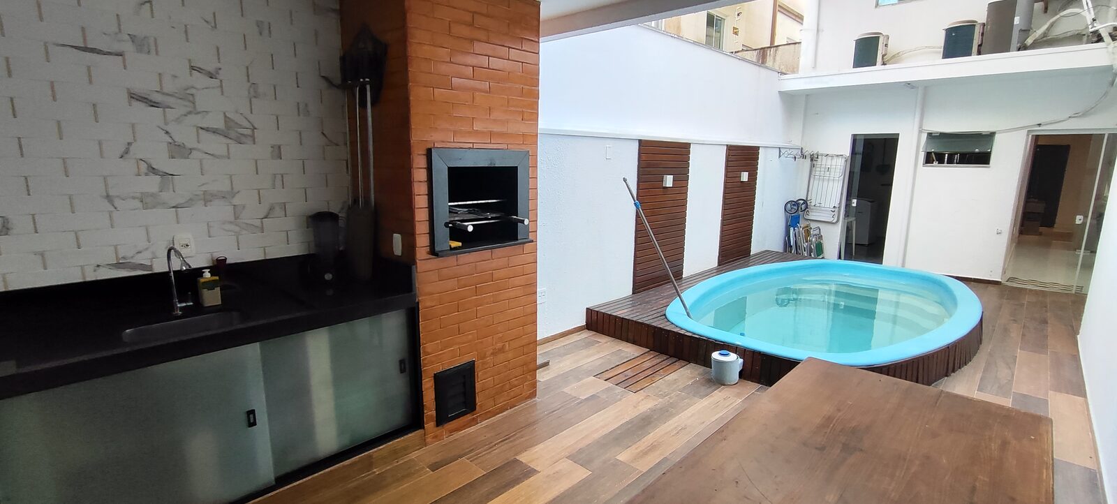 Área da piscina com churrasqueira embutida