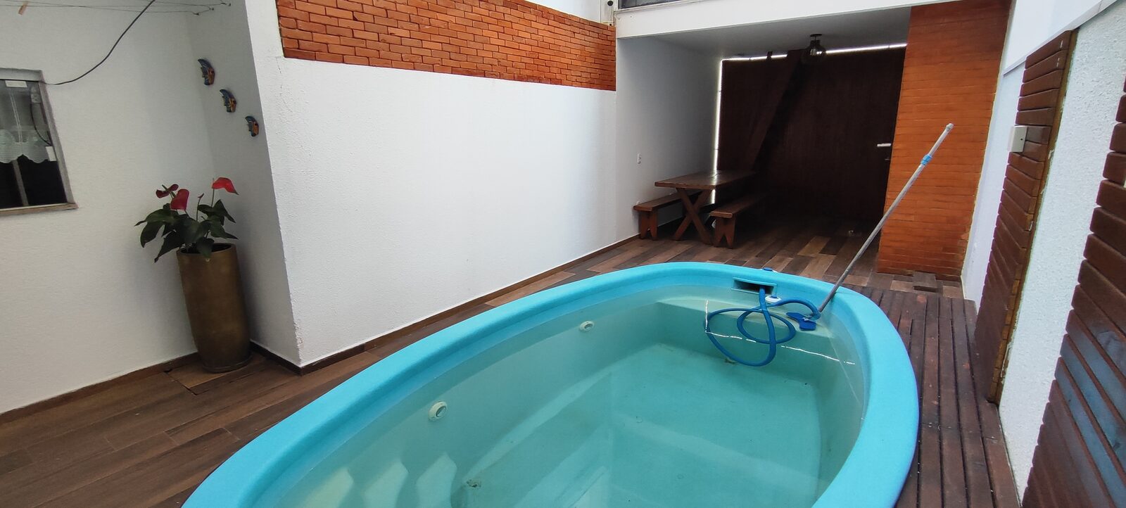 Piscina de fibra na área coberta do térreo, ao lado da churrasqueira