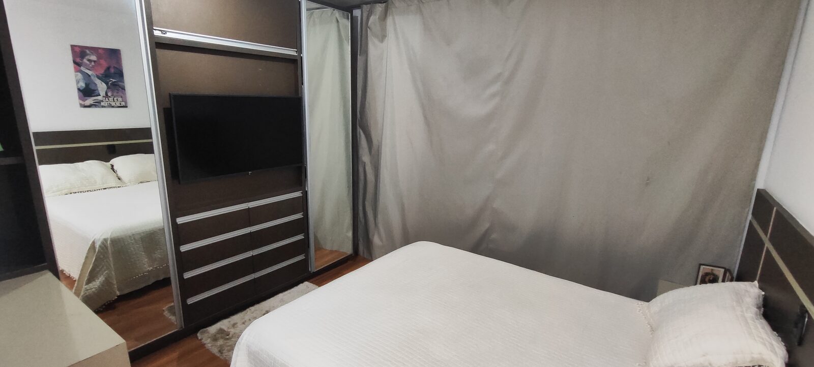Quarto com cama de casal e cortina