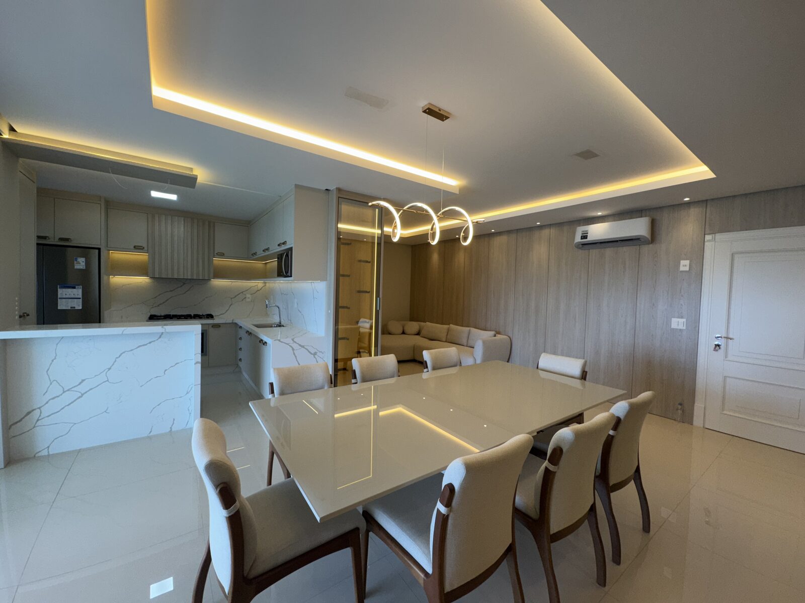 Sala de jantar com mesa para oito e iluminação de destaque