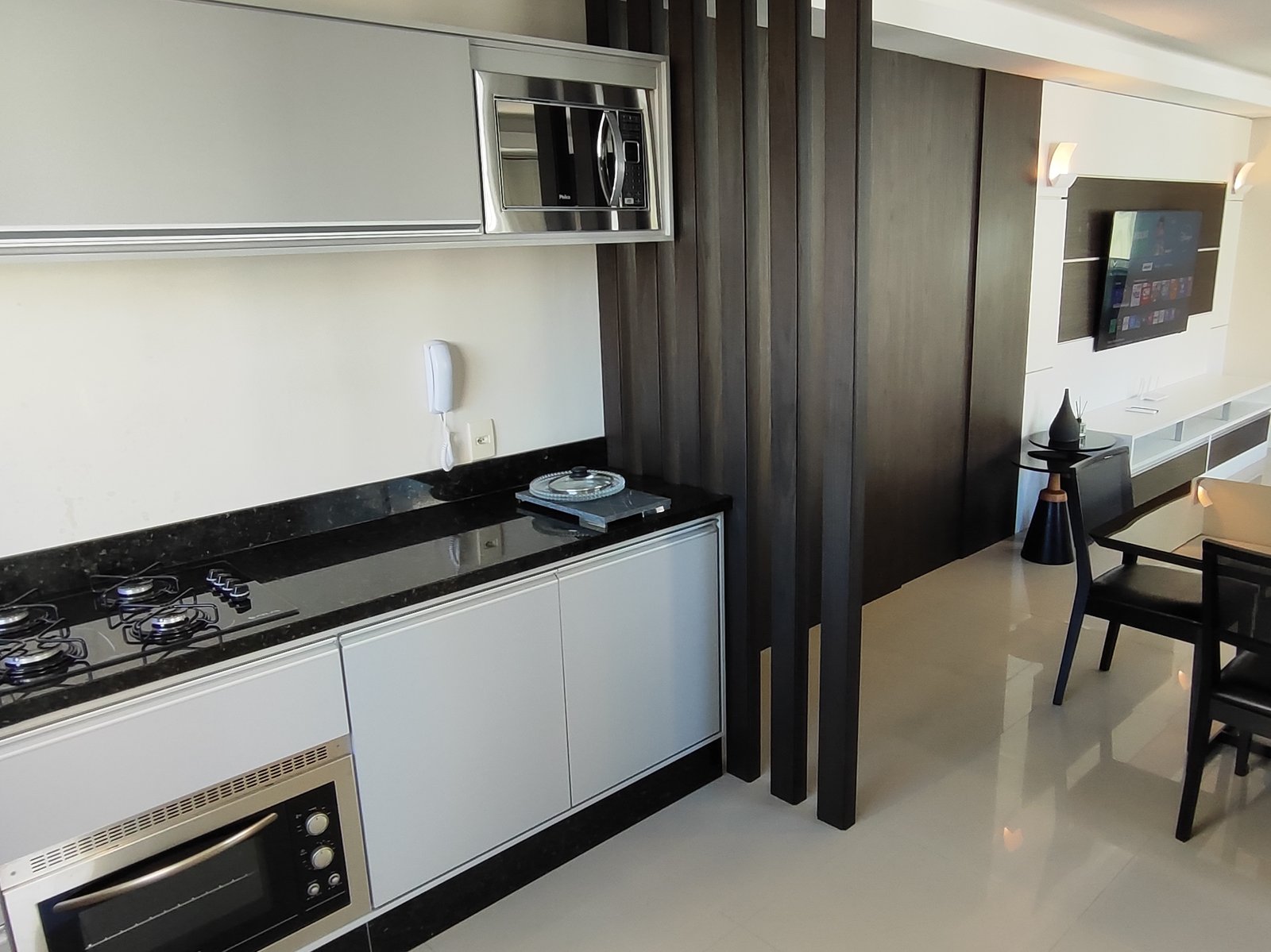 Cozinha com bancada de granito preto e cooktop