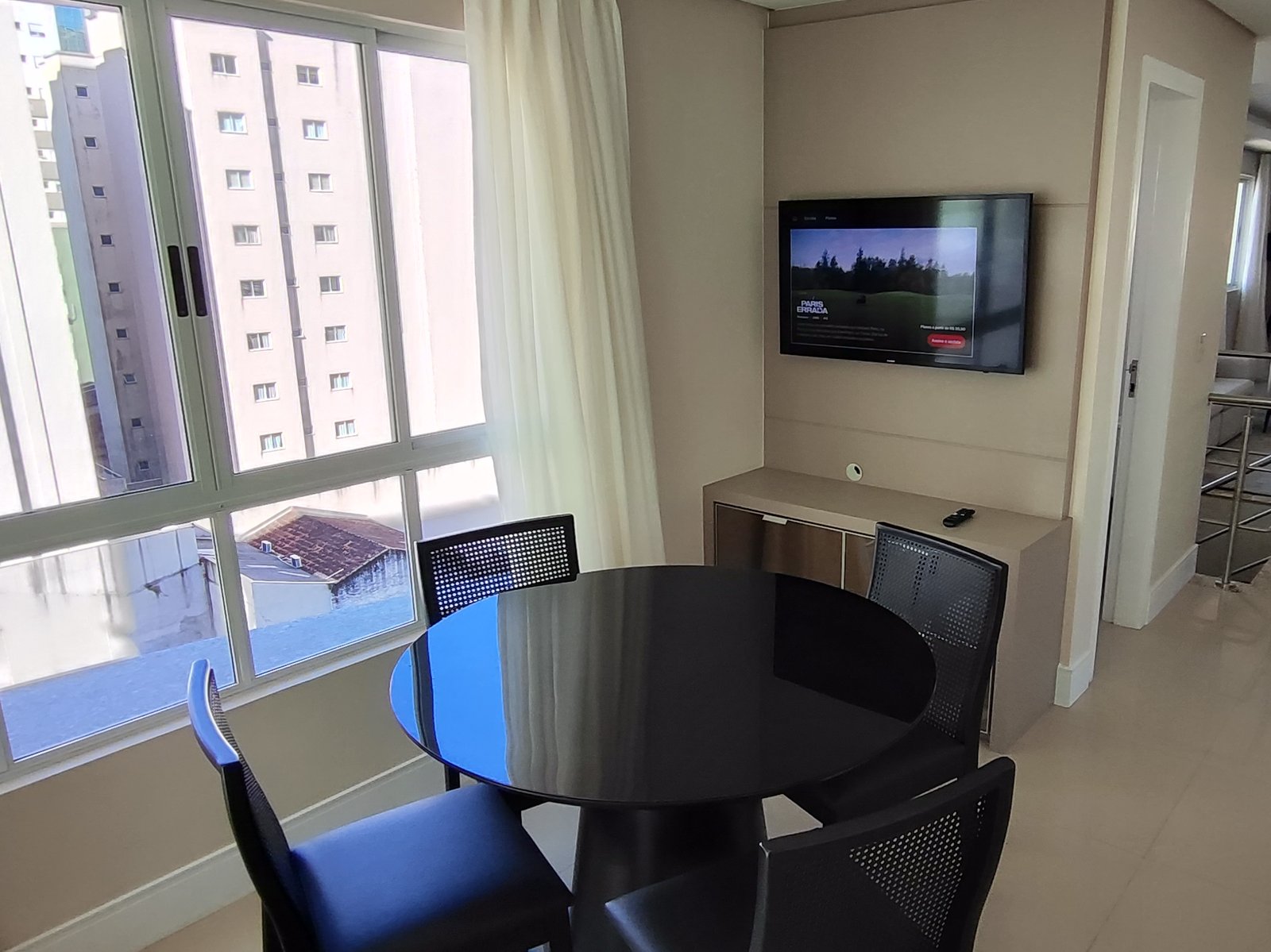 Segundo estar do andar de cima com mesa redonda e TV