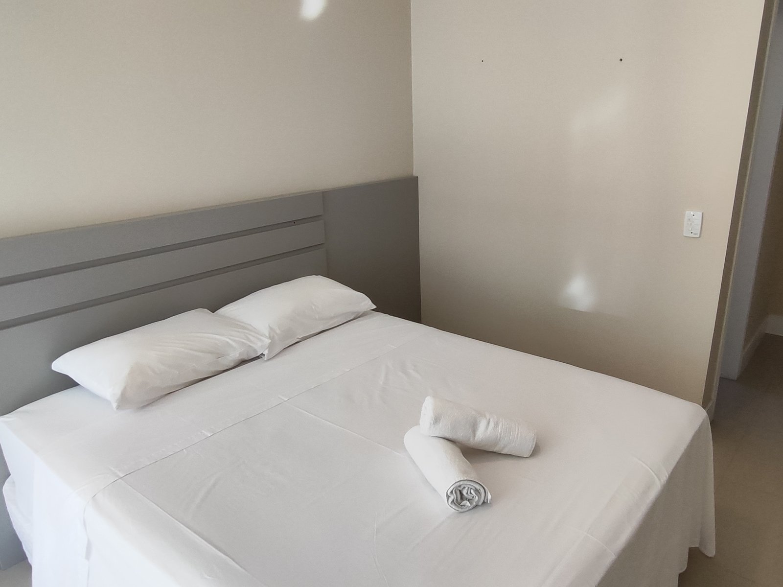 Suíte com cama de casal e cabeceira ripada