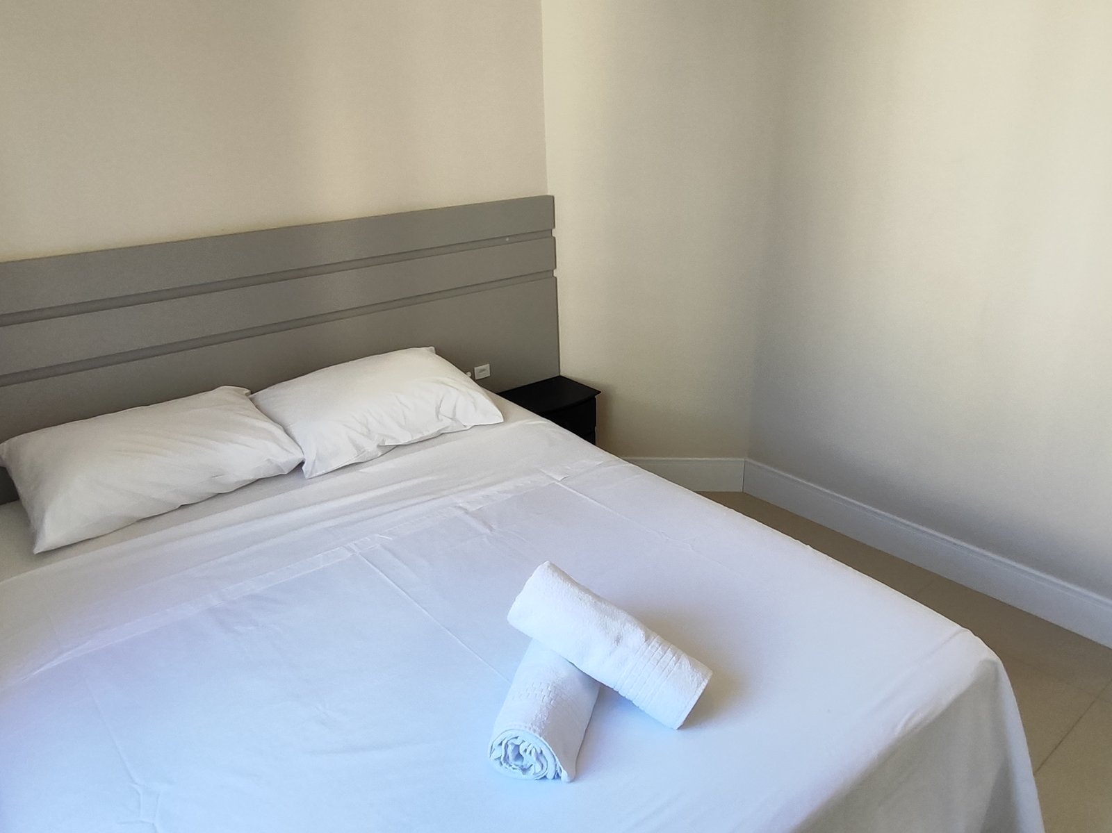 Suíte com cama de casal e cabeceira ripada