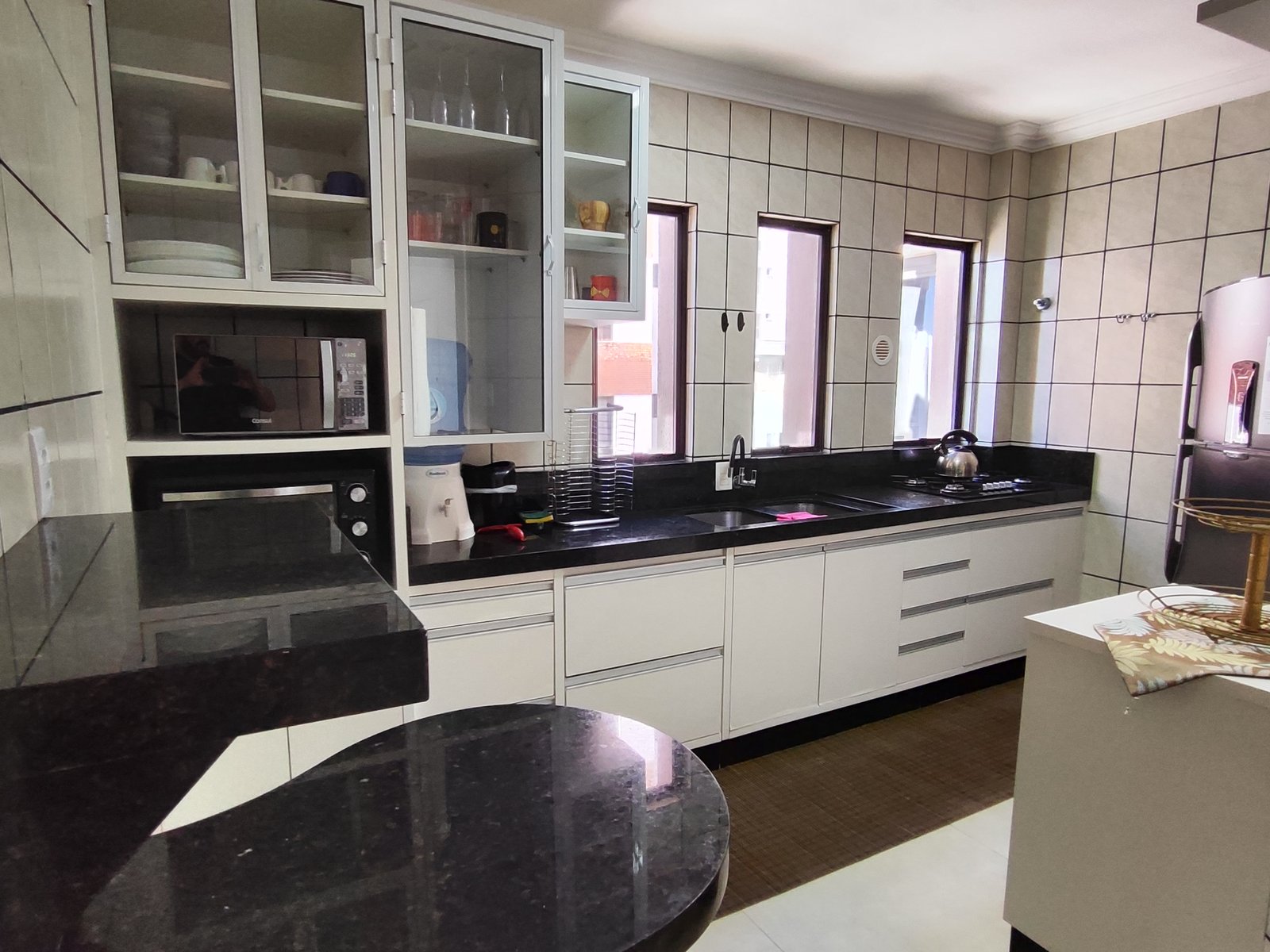Cozinha equipada com bancada em granito preto e fogão