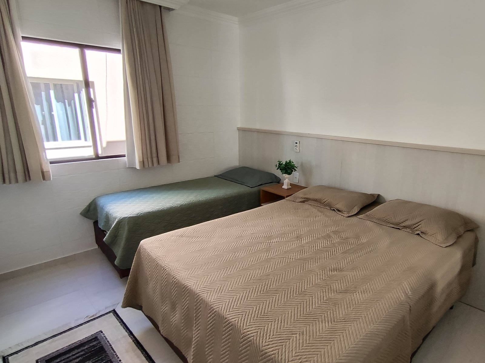 Quarto com cama de casal e cama de solteiro