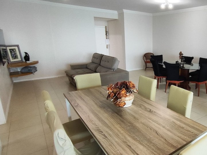 Sala de jantar com mesa retangular e mesa redonda de vidro
