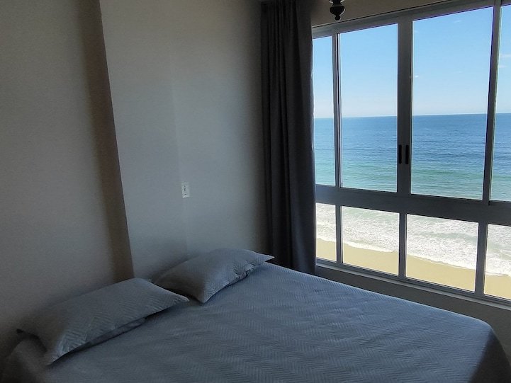 Suíte com cama de casal e vista mar direto da cama