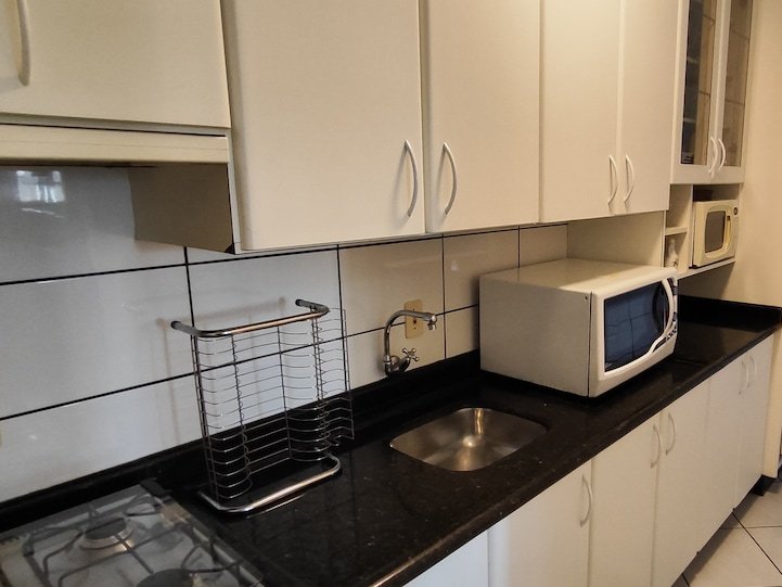 Cozinha equipada com fogão, geladeira e micro-ondas