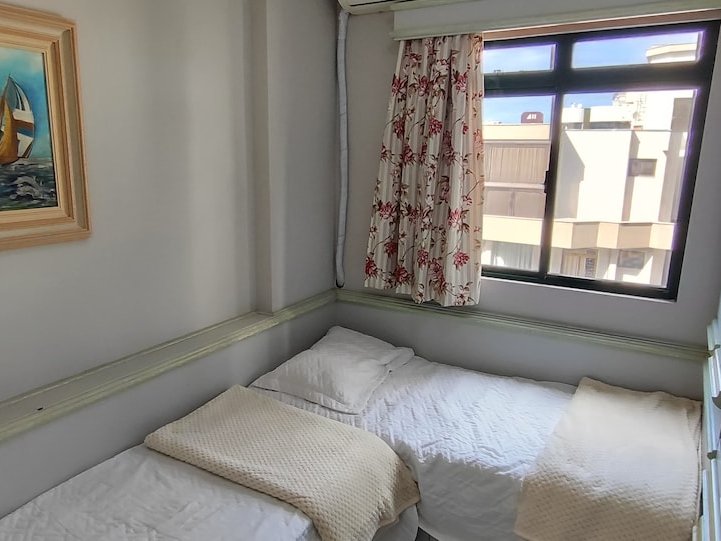 Quarto com 2 camas de solteiro e quadro de veleiro