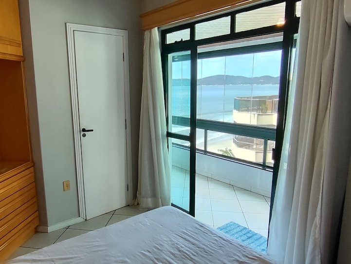 Suíte de casal com vista mar pela porta de vidro