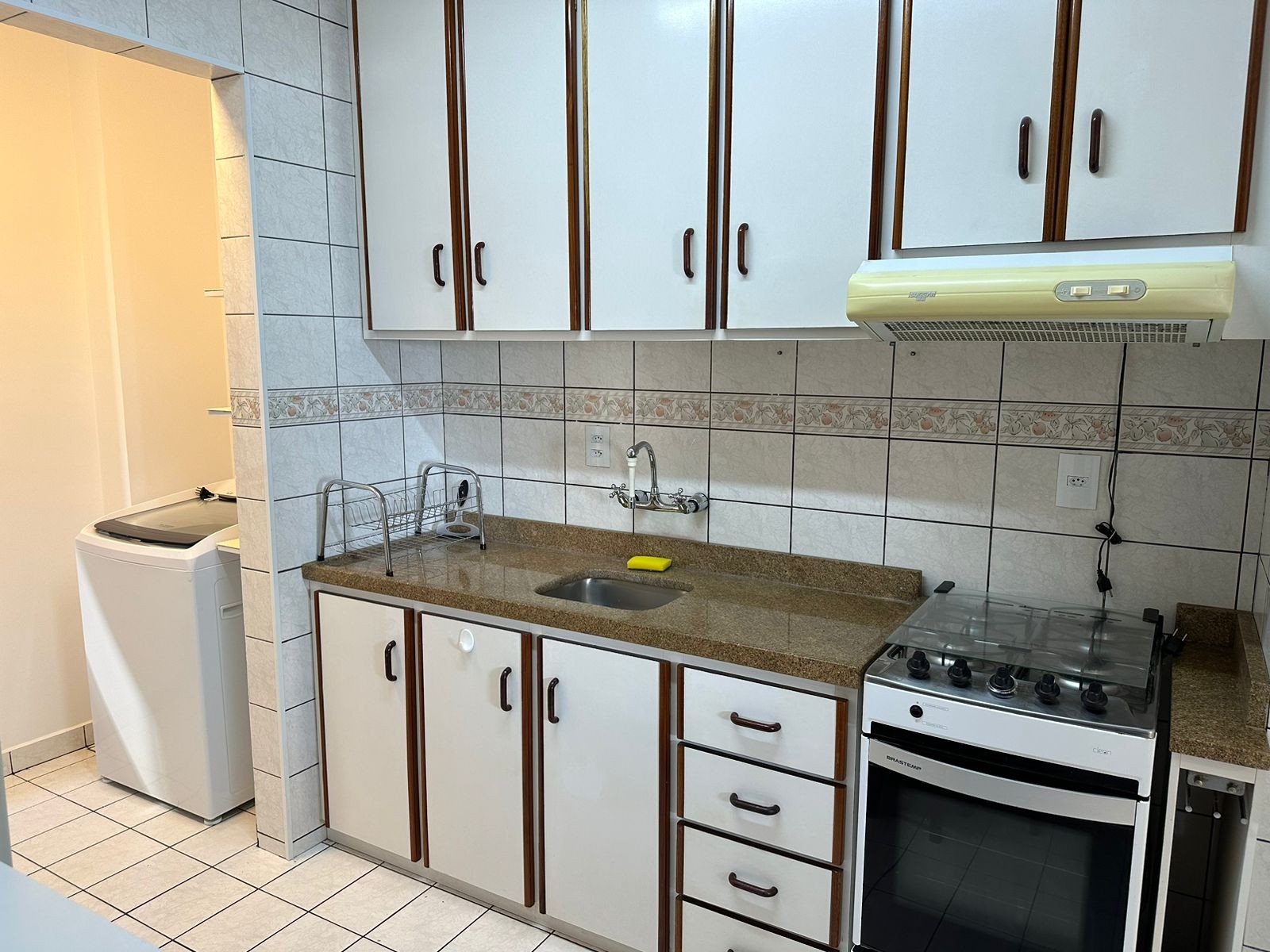 Cozinha completa em formato corredor, com fogão e geladeira