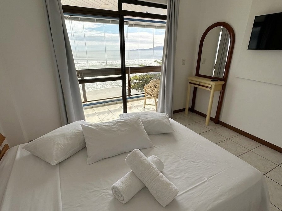 Quarto com cama de casal, penteadeira e TV