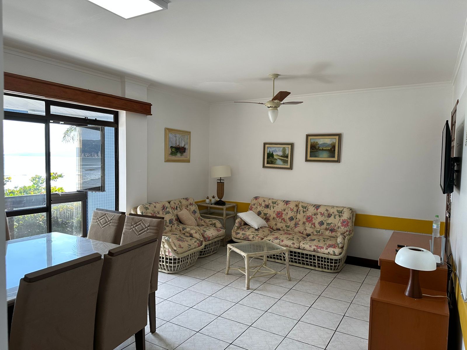 Sala de estar com mesa de jantar para 6 pessoas e sofá