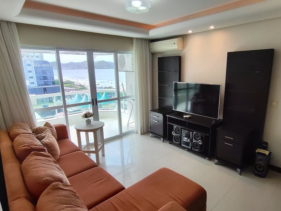 Sala de estar integrada com sofá e Smart TV