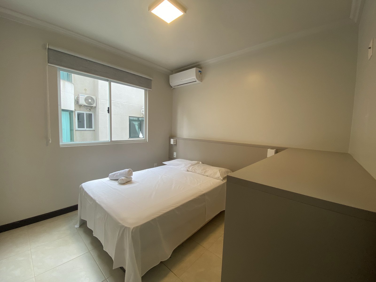 Quarto com cama de casal e janela