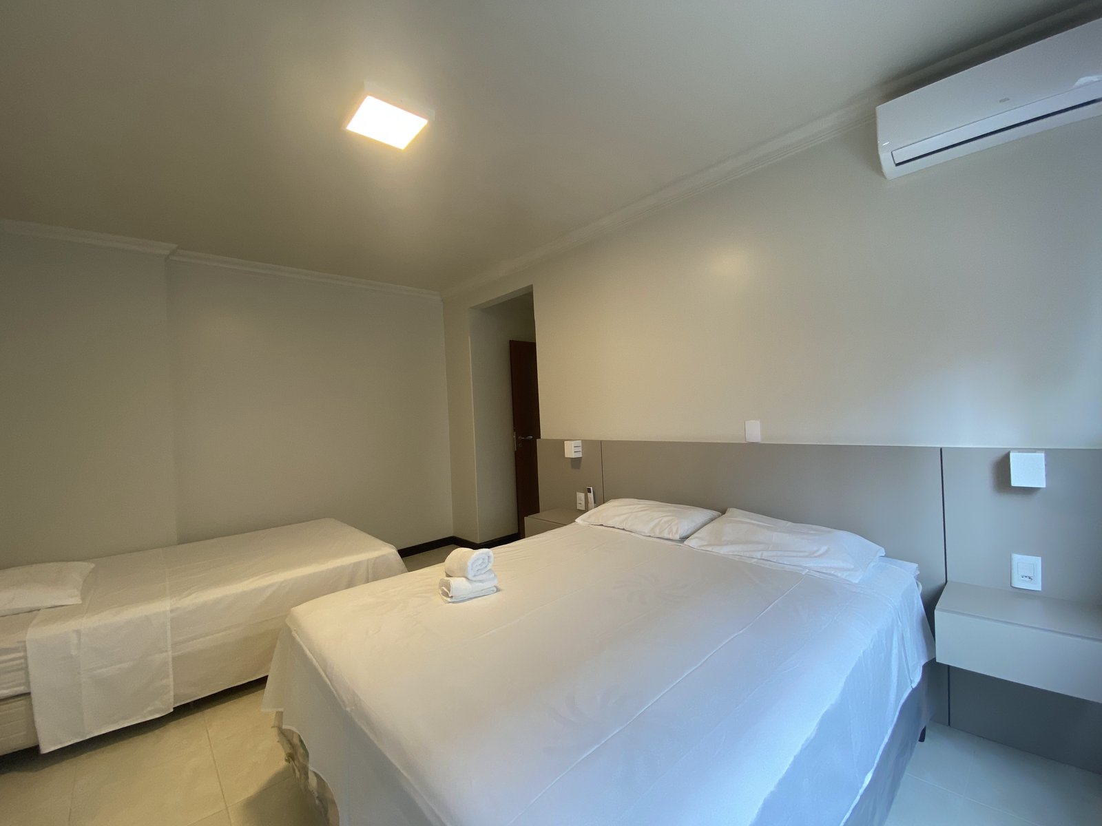 Quarto com cama de casal e cama extra