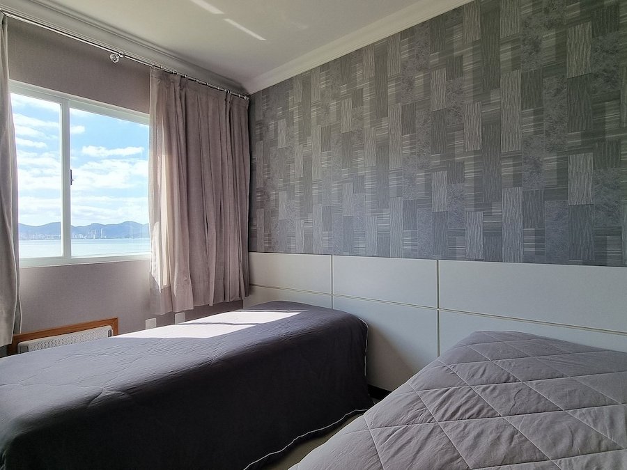 Quarto com duas camas de solteiro e vista mar