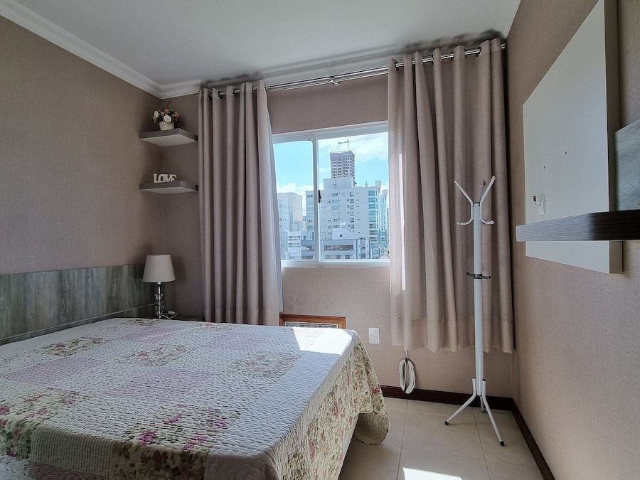 Quarto com cama de casal e parede floral rosa
