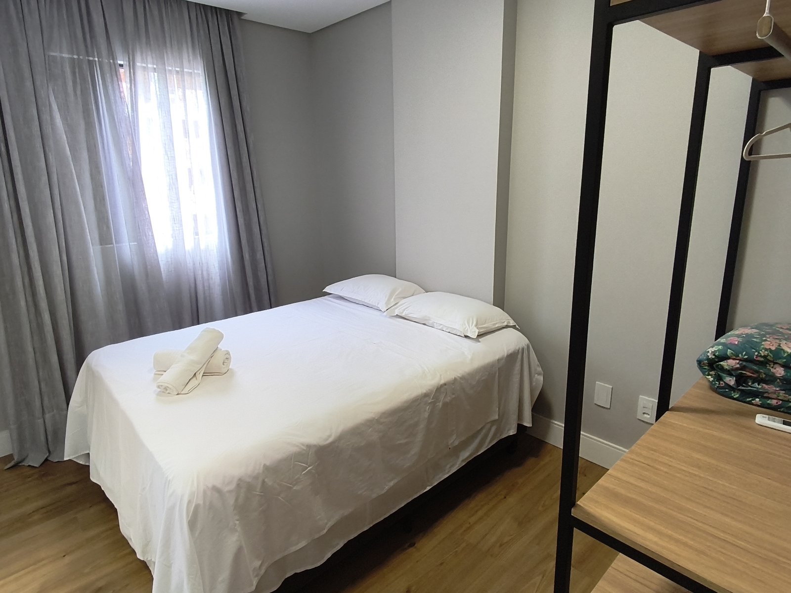 Quarto com cama de casal e estante industrial em metal preto