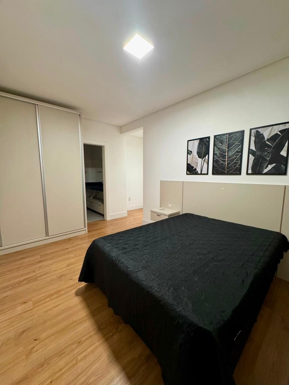 Suíte com decoração em tons de preto e cama de casal