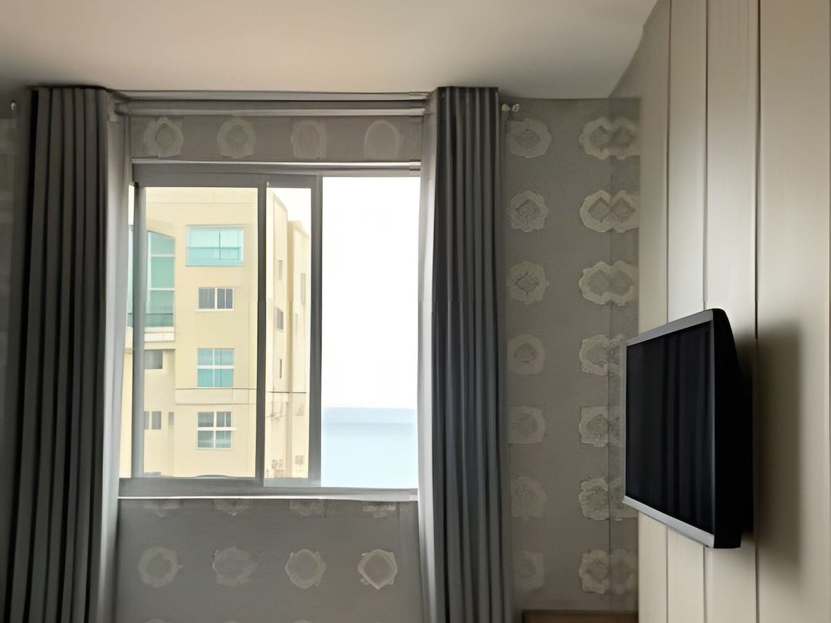 Quarto com vista mar parcial pela janela