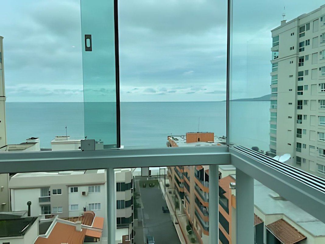 Sacada com vidro do chão ao teto e vista mar