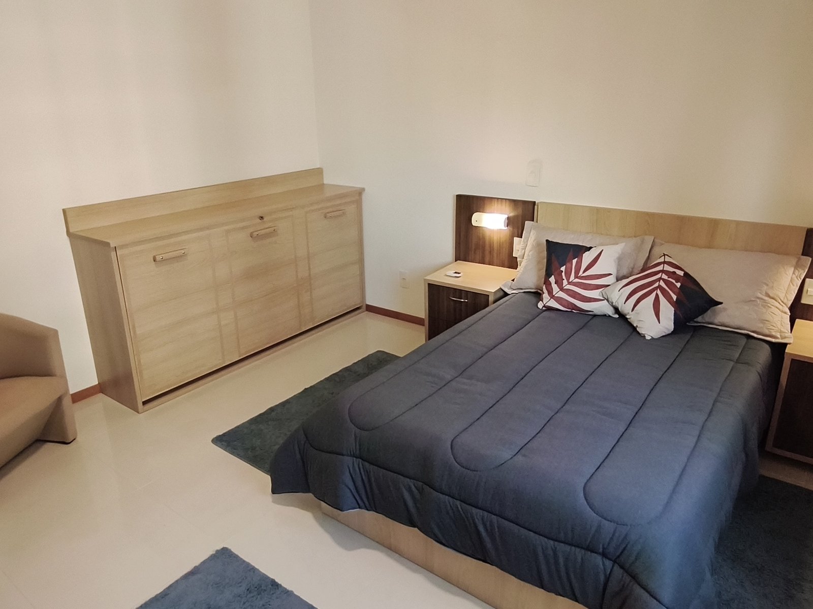 Suíte com cama de casal e cabeceira com luminárias de leitura