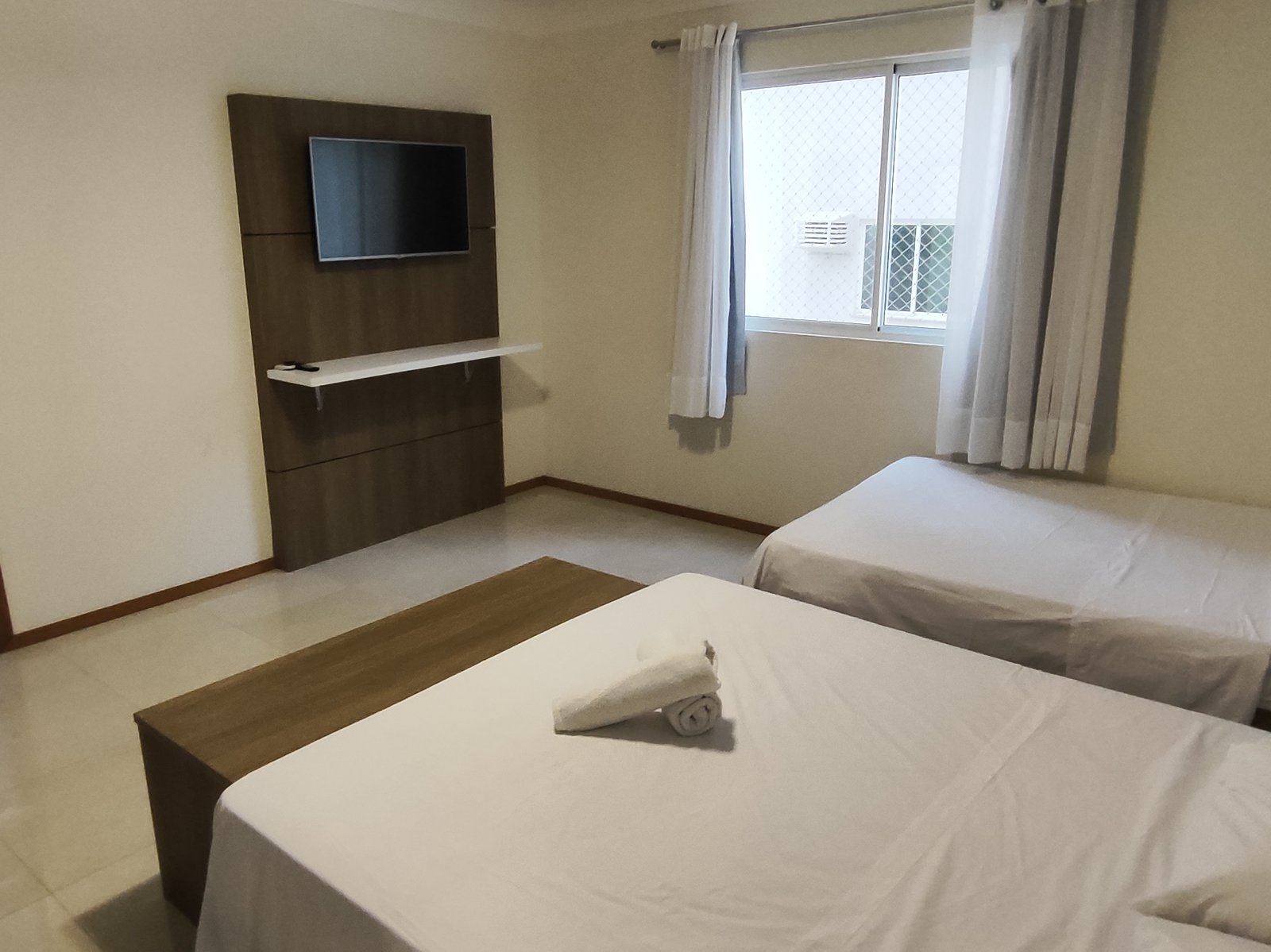 Quarto com cama de casal e cama de solteiro, banheiro próprio