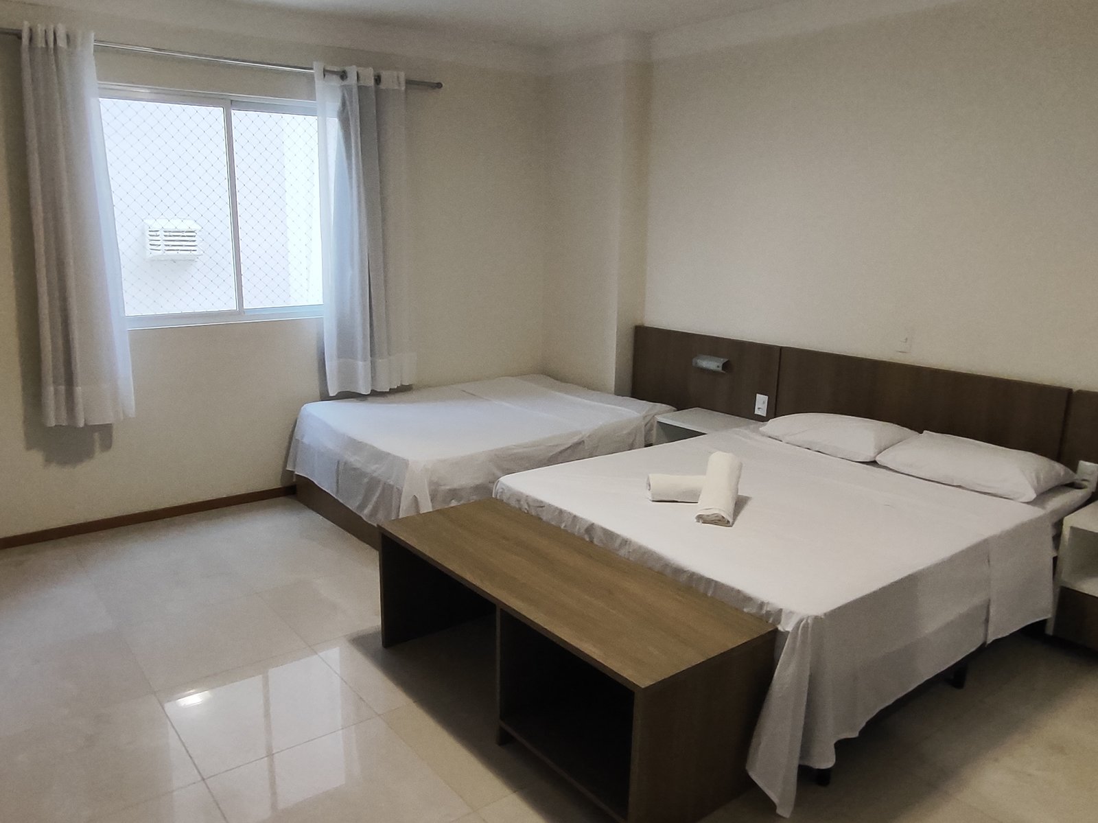 Quarto com duas camas de casal e TV