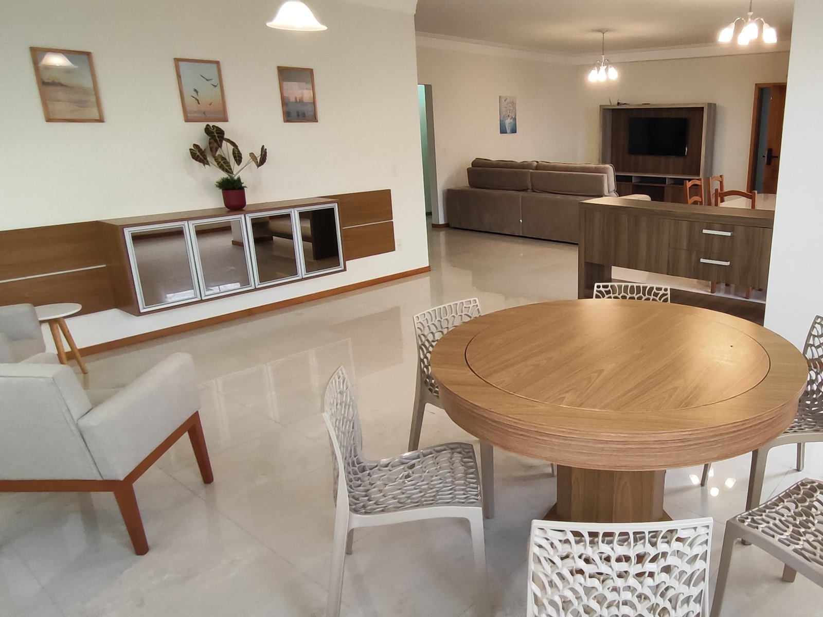 Sala de estar com mesa redonda, sofá e TV