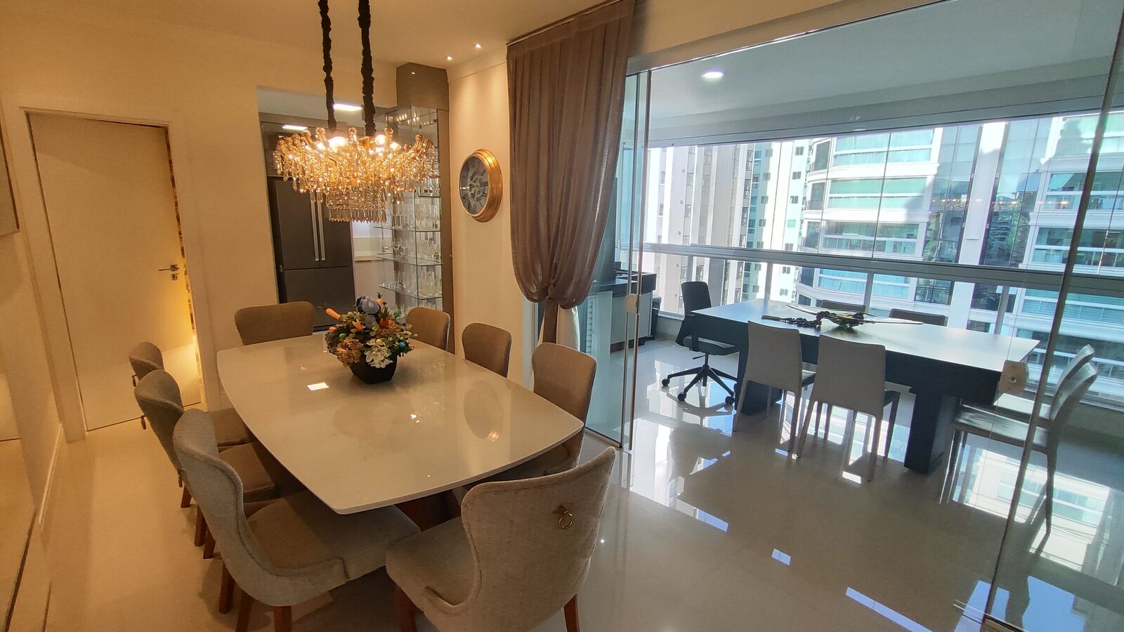 Sala de jantar com lustre e vidraça do piso ao teto