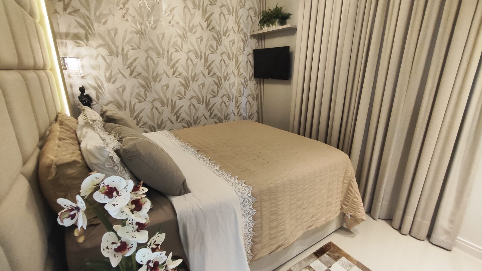 Suíte com cabeceira estofada e papel de parede floral