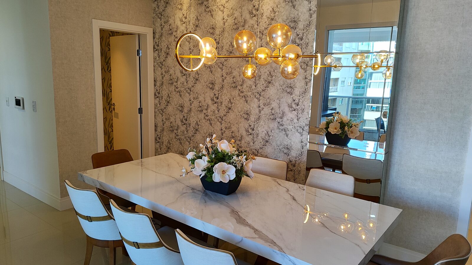 Sala de jantar com mesa de mármore e lustre