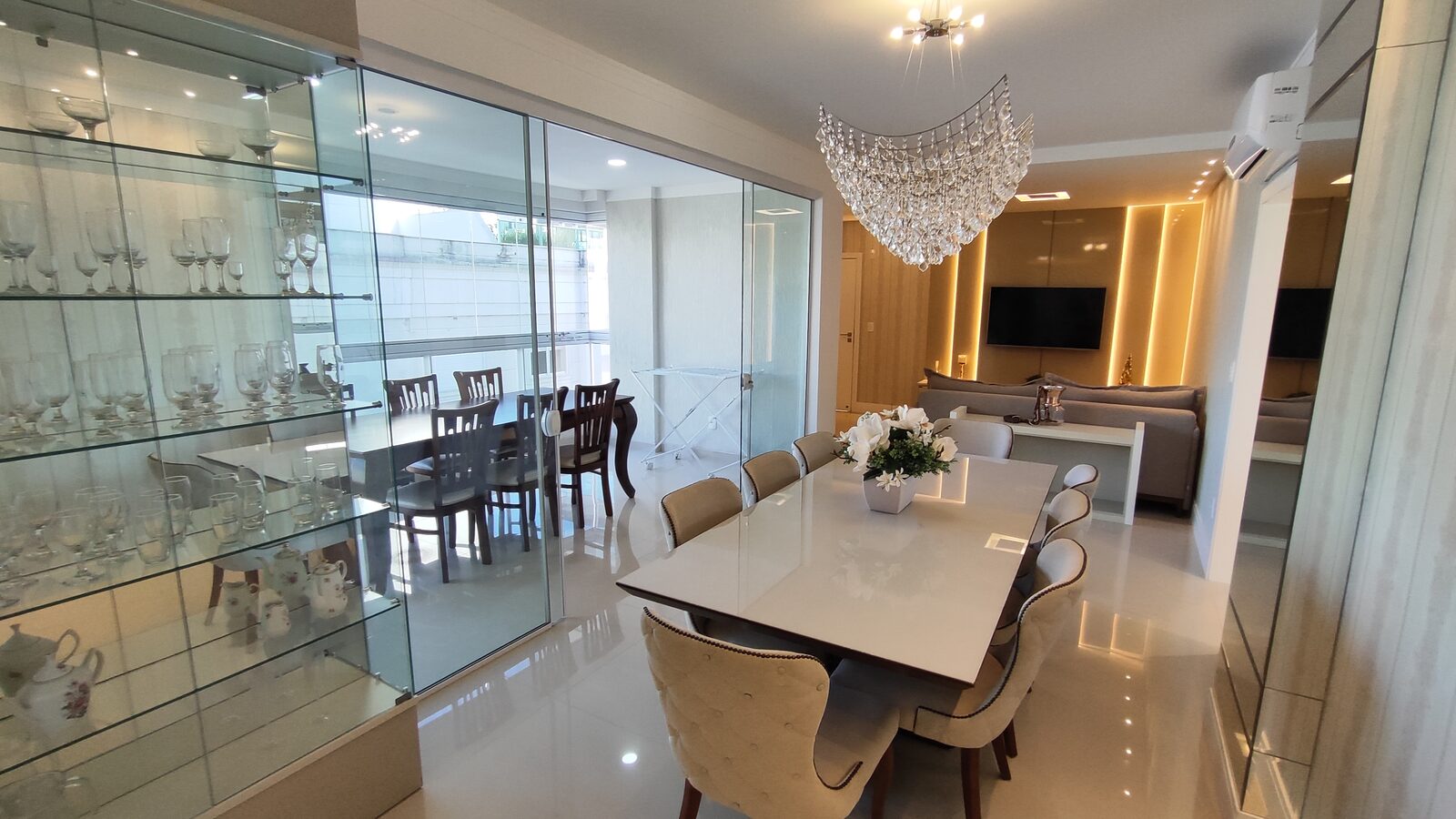 Sala de jantar com adega de taças e integração com a sala de estar