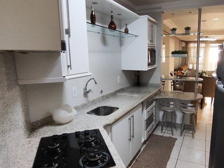 Cozinha equipada com cooktop e bancada de granito