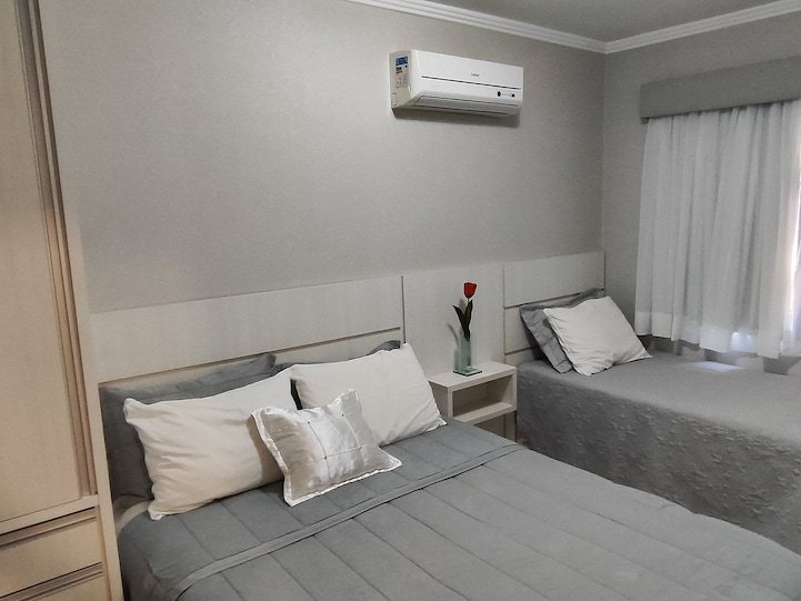 Quarto com cama de casal e cama de solteiro