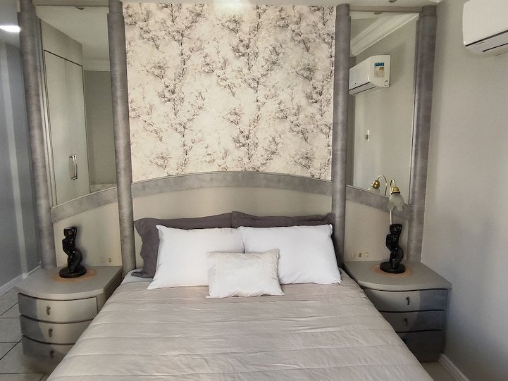 Quarto com cabeceira e papel de parede floral