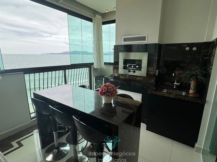 Varanda gourmet com bancada em granito, churrasqueira e vista mar